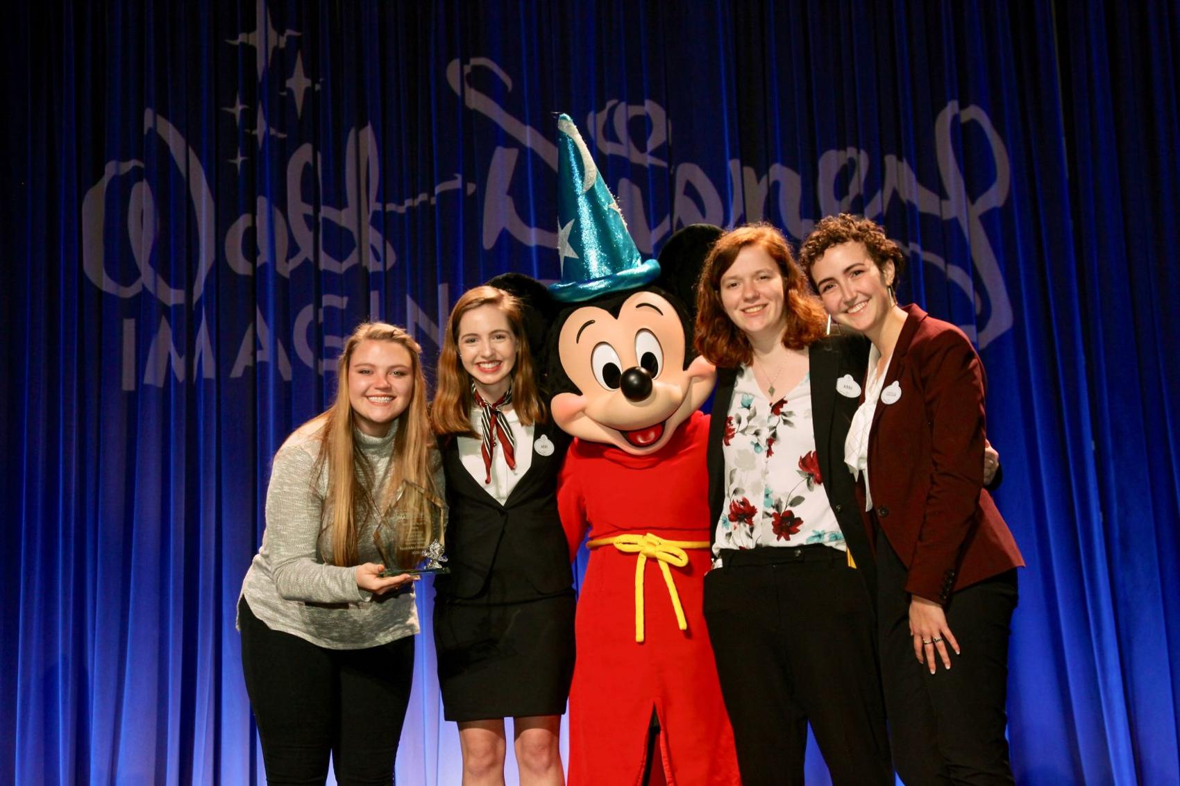 Kennedy Behling, Abby Zuber, Abby Henning and Cecilia Gonzalez stand with Mickey Mouse after winning second place at Disney’s 2020 Imaginations Design Competitions. .