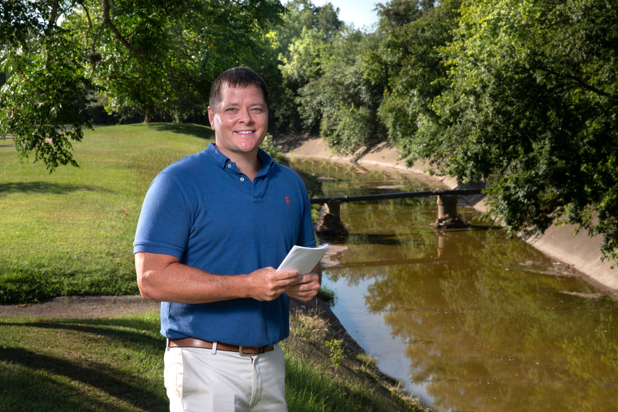 LAUP associate professor Galen Newman stands in front of a river. 