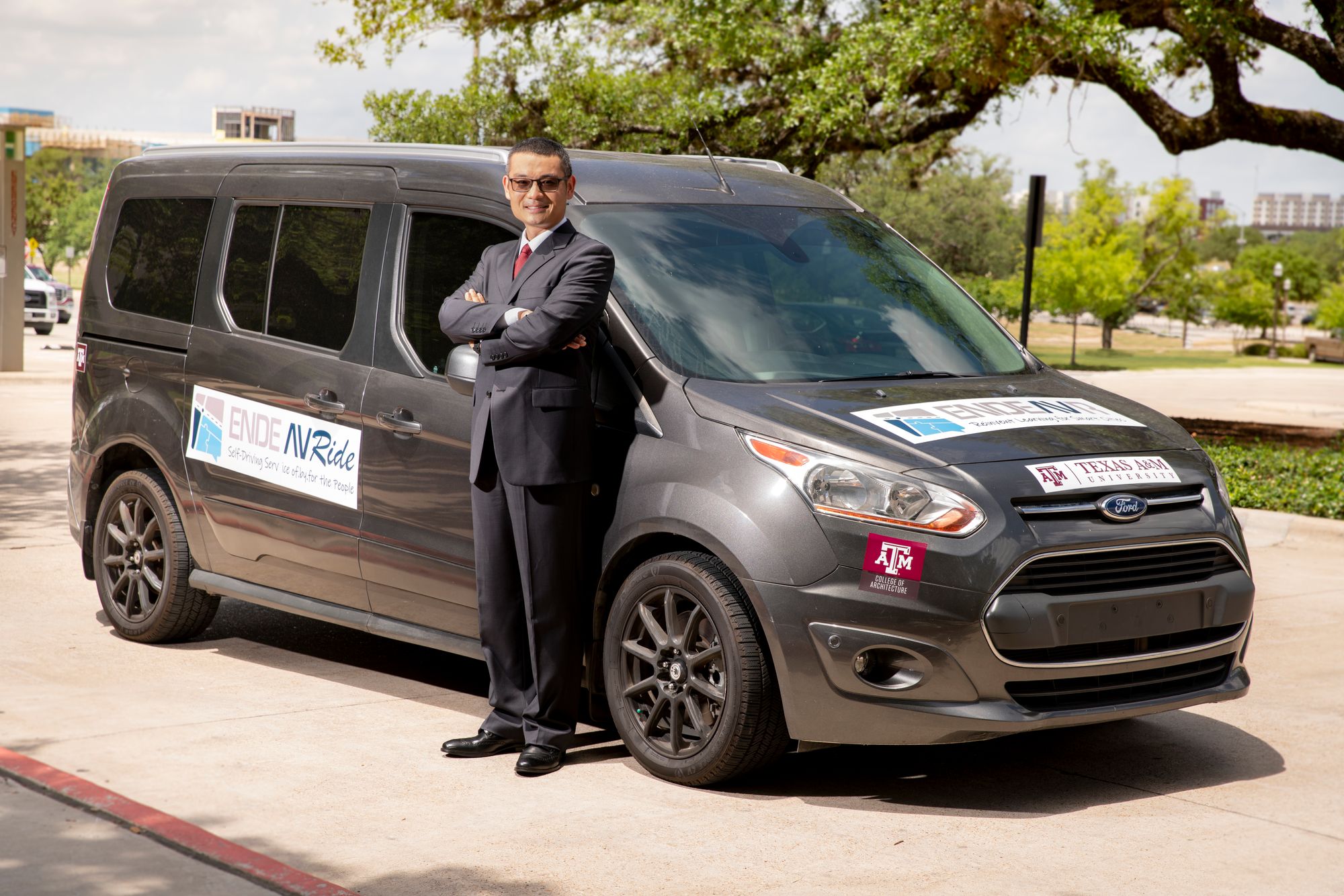 Wei Li stands in front of the ENDEAVR smart van.