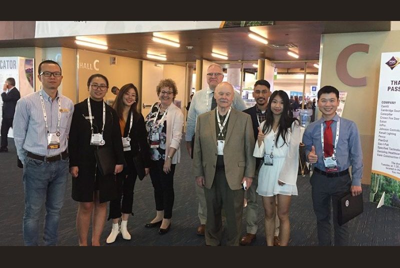 Shea students and professors wearing lanyards attend a convention