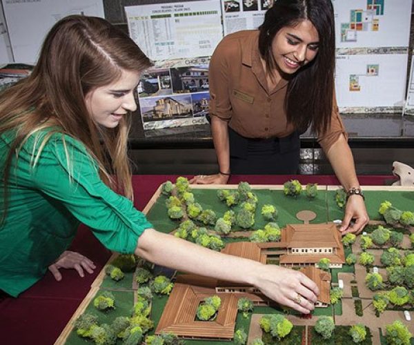 Two students work on a small landscape architecture model