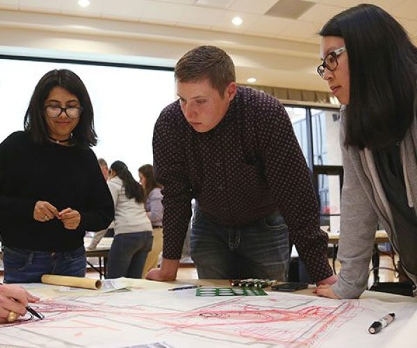 Three students review landscape architecure design plans 