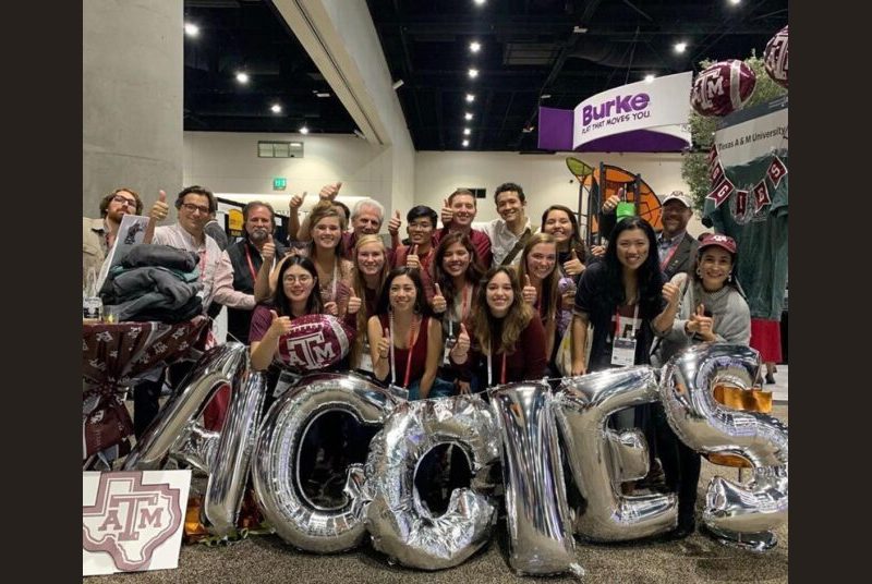 Students give the gig 'em behind giant balloon letters that spell out, 