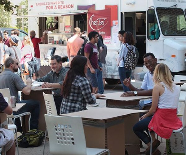 People order from and gather around a food truck