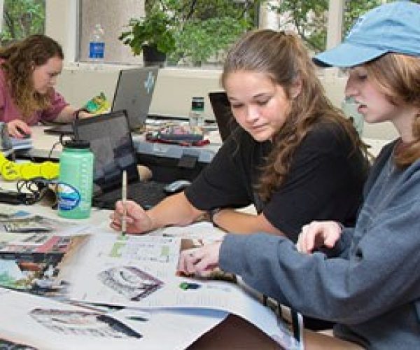 Students are surrounded by design plans while working in a studio