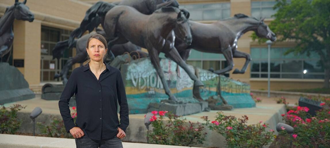 Susanneh Bieber stands in front of public art