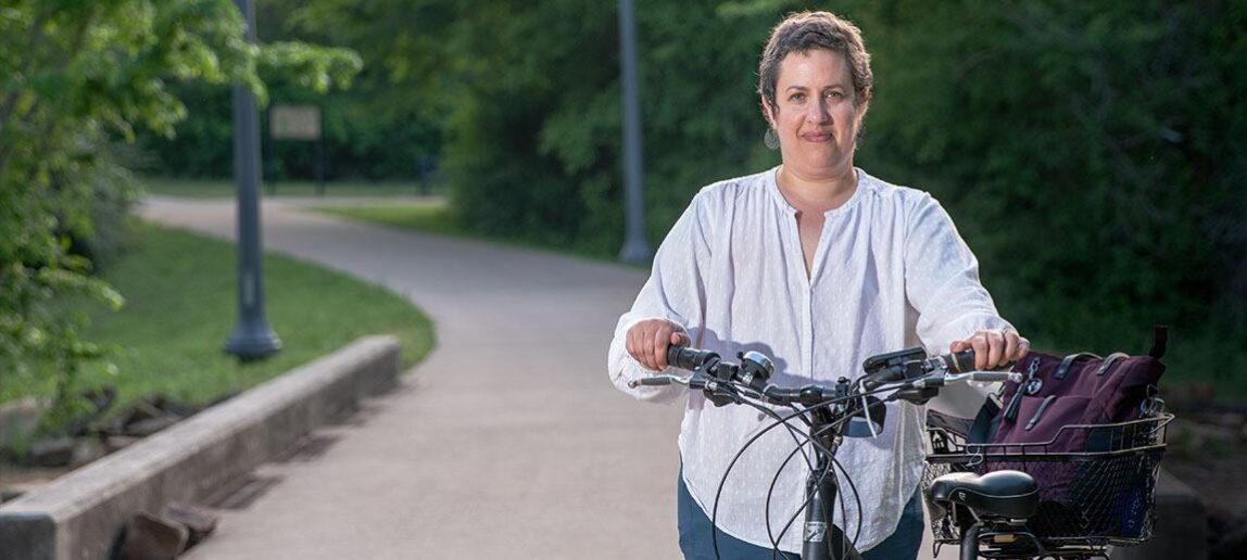 Tara Goddard stands next to a bicycle