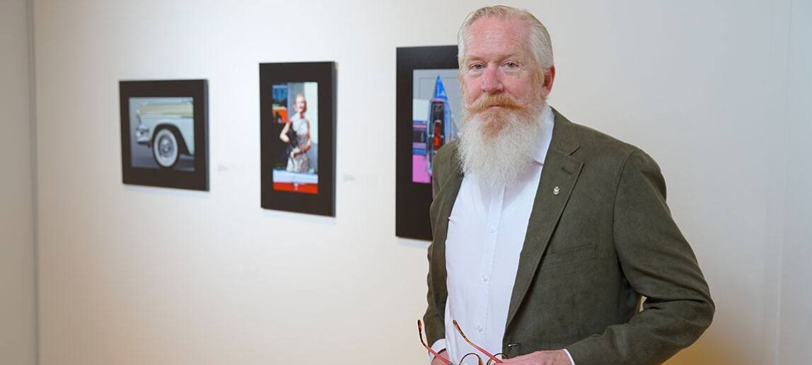 Russell Reid stands in front of his artwork