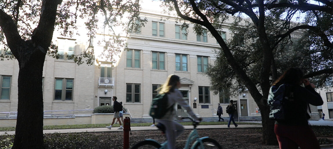 Student rides bicycle on A&M campus