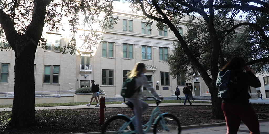 Student rides bicycle on A&M campus