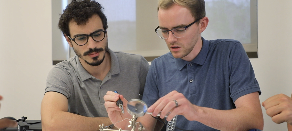 Two students program a sensor