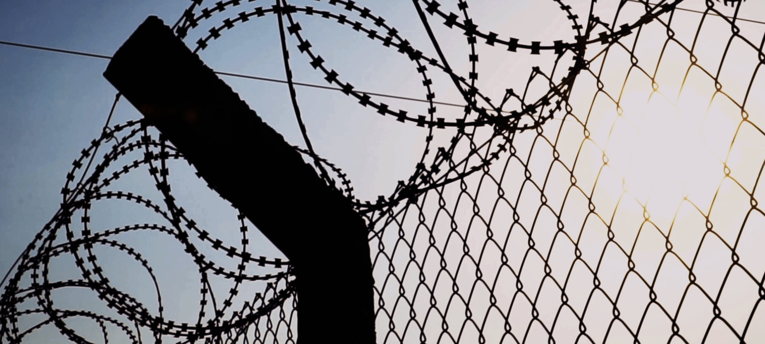 silhouette of barbed wire prison fence