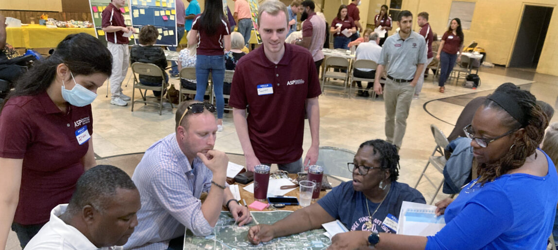 People talk around a table with urban planning students