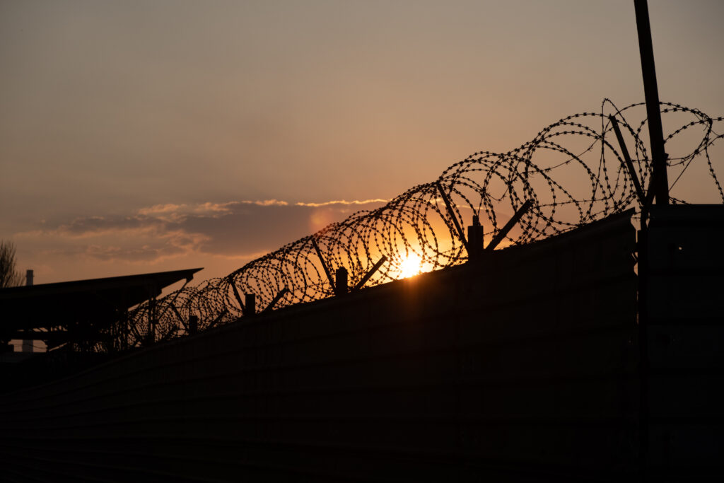 Silhouette of barbed wire fence with twilight sky. Barbed wire of restricted area