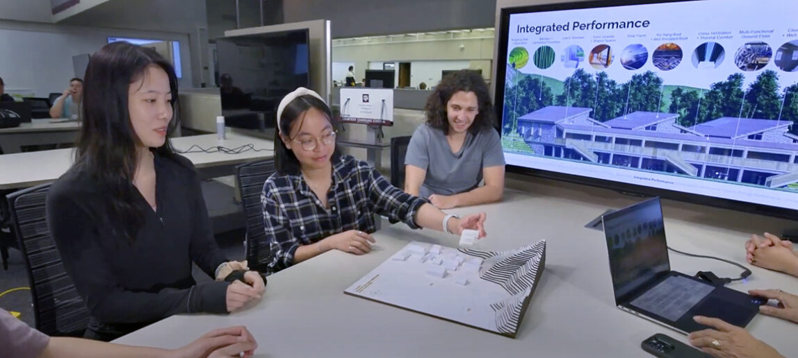 three students look at architectural model with an image of the model on a monitor