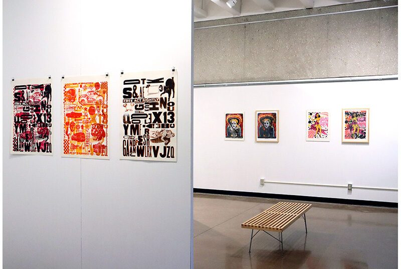 On the left, 3 graphic prints on the walls feature various texts created with different shapes and sizes of letters. In the background, a wooden bench is in front of 4 posters on the wall.