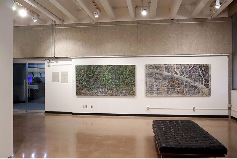 A view of 2 artworks. The artwork on the left features green grass, newspaper clippings, and black text. The artwork on the right features a white tree branch, newspaper clippings, and black outlined text.