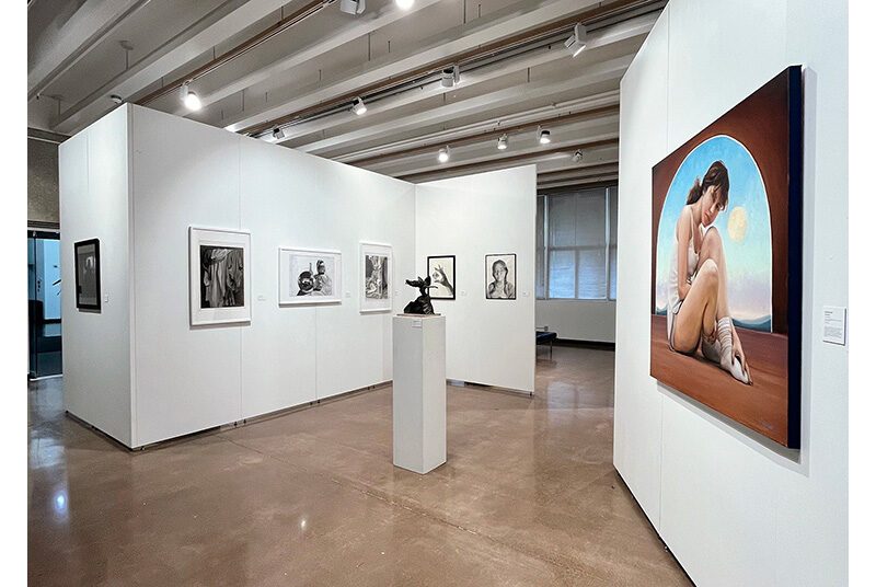 A view of the Fresh Forward student exhibition featuring 6 framed drawings on the wall in the background, 1 plastilina sculpture on a pedestal in the middle, and 1 large oil painting wall on the right.