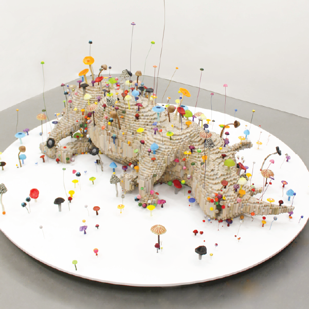 A rhinoceros on its side, covered in tiny colorful mushrooms that resemble umbrellas. This is an example artwork from Shawn Smith's Dissonant Data exhibition.