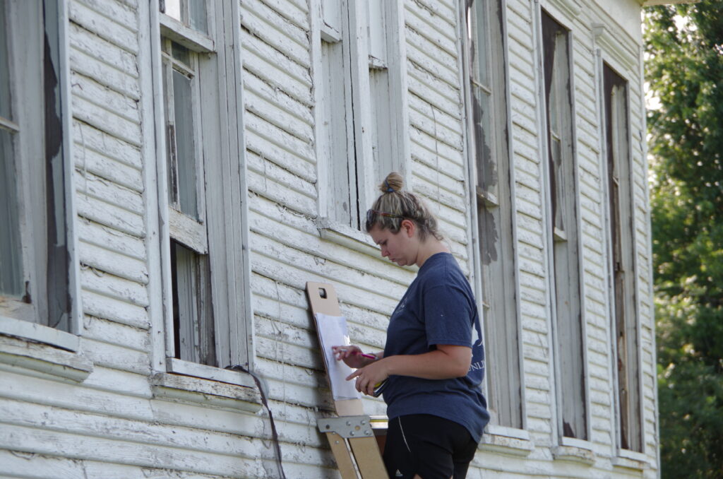 College of Architecture Student surveying windows at the Wheelock School House