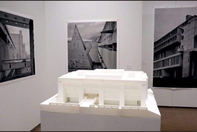 A 3D-printed model of Texas A&M’s Langford Building on a white pedestal with “La Tourette Convent #3” on a white wall behind it.