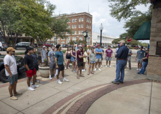 A group of students on a walking tour of downtown Bryan.