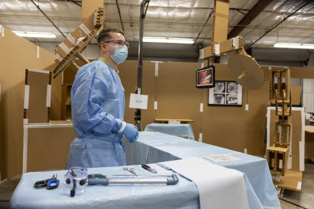 Graduate architecture student participating in operating room mock-up simulation.