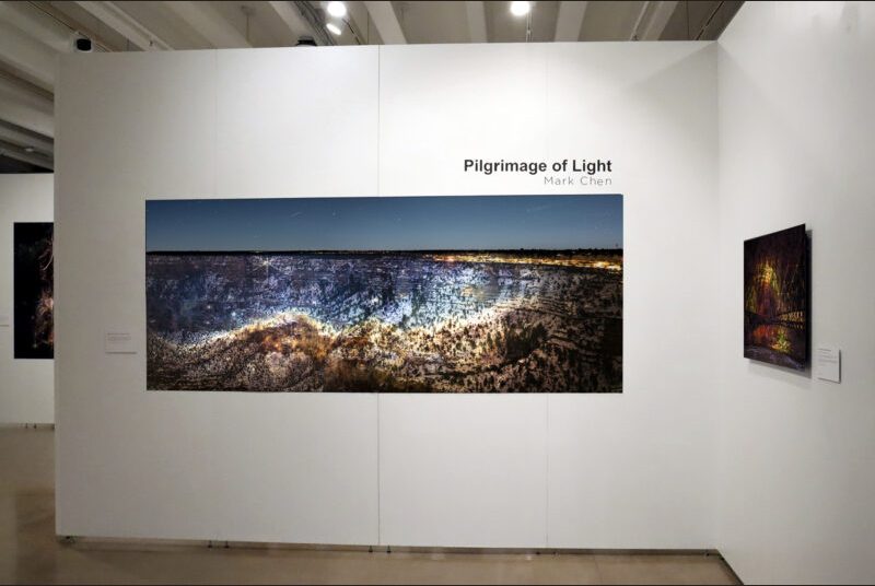 A large-scale photograph of space imagery projected on the Grand Canyon. Above the artwork, there are black letters spelling the artist’s name, Mark Chen, and title of the exhibition: Pilgrimage of Light.