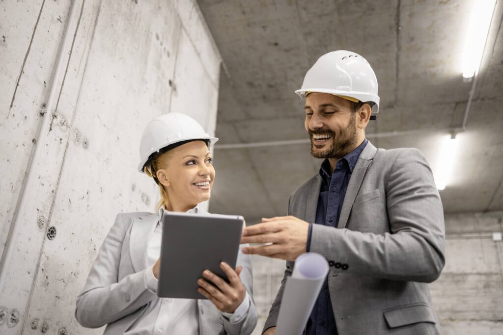 Civil engineer and architect visiting construction site and discussing about new project plan on tablet computer.