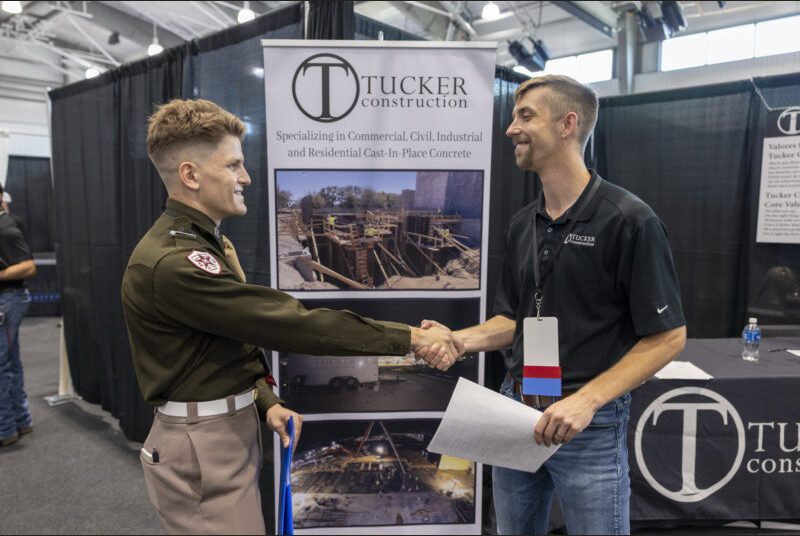 A student shakes a recruiters hand.