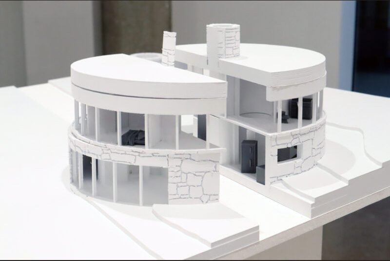 A white small scale model of a two-story round house.