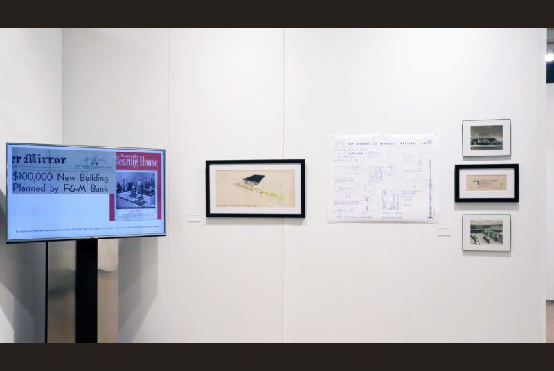 A digital monitor on the left, a painted elevation, blueprint, and a vertical grouping of 3 images of a bank designed by the architect.