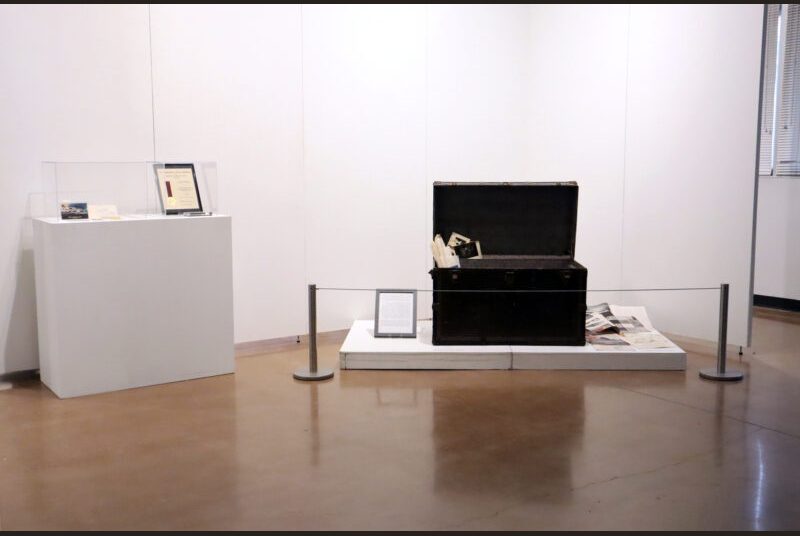A pedestal and large trunk that is propped open with the architect’s memorabilia.