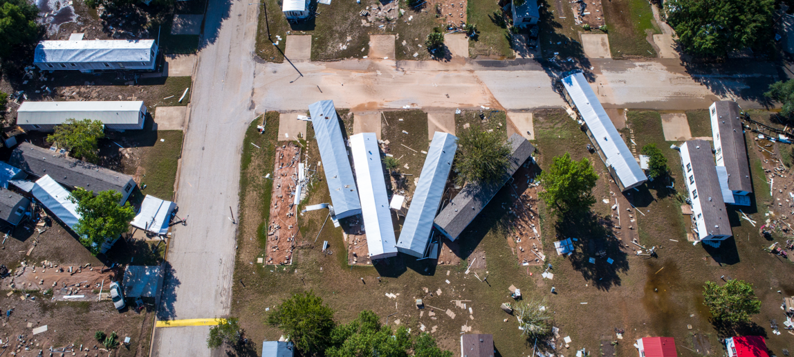 An aerial view of a neighborhood that has been heavily impacted by storms.