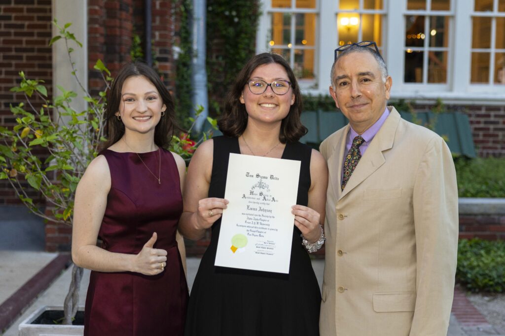 Emma Johnson holds her Tau Sigma Delta certificate, standing with Lindsay Poe and Professor Marcel Erminy at the Spring 2025 Banquet.