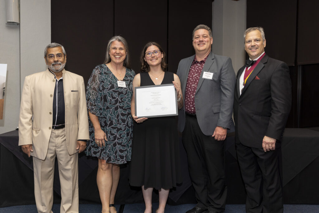 Emma Johnson holds a certificate recognizing her as the first student in Texas to complete the Integrated Path to Architectural Licensure program. She stands with her parents and IPAL/AXP Coordinator Dr. Valeiran Miranda (left) and Department Head of Architecture, Dr. Gregory Luhan, FAIA, from the Department of Architecture.