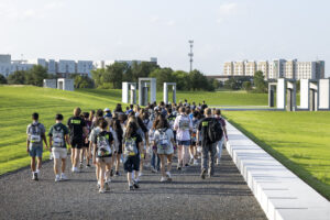 A large group of students walk together toward the Bonfire Memorial.