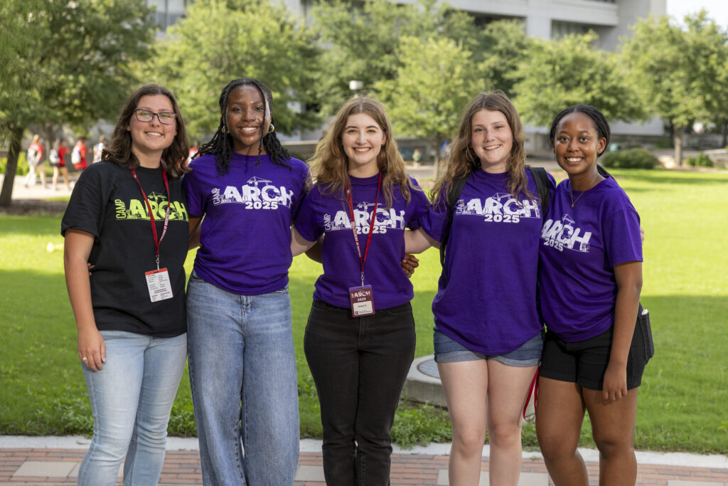 An instructor and four camp attendees smile and pose.