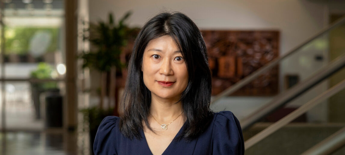 Dr. Lingqian “Ivy” Hu standing in the Langford Building with a blurred background.
