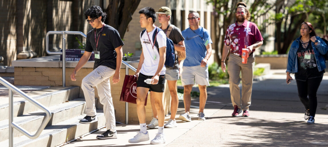 A small group of incoming students walk into Francis Hall for a Texas A&M New Student Conference.