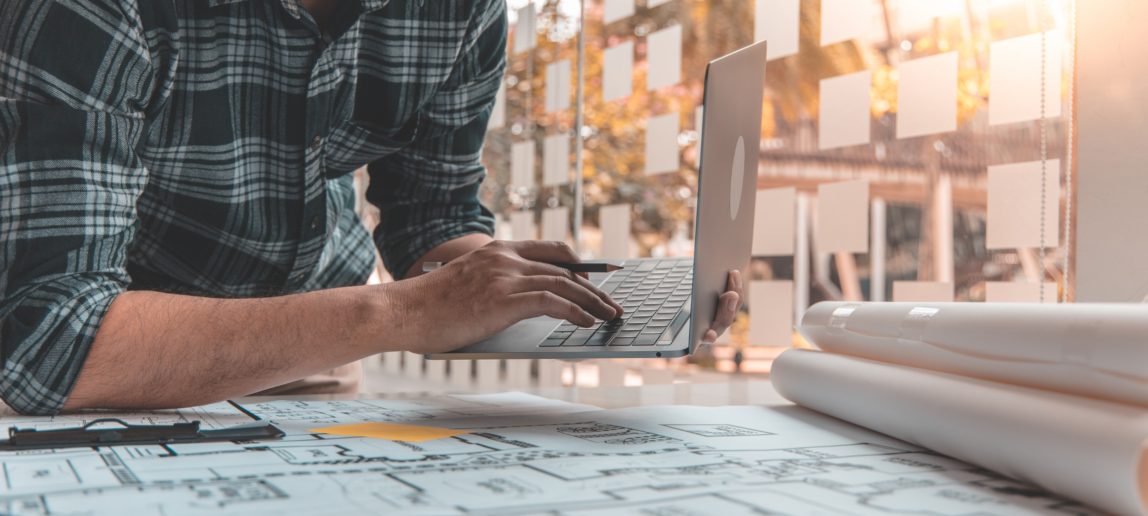 A person working at a desk and using a laptop. Photo by: canva.com.