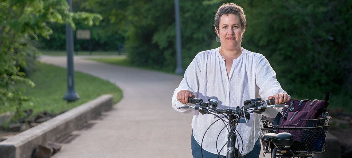 Tara Goddard stands next to a bicycle